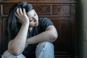 sad woman in withdrawal sitting on floor